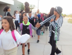 Staff high-fives students as they enter school